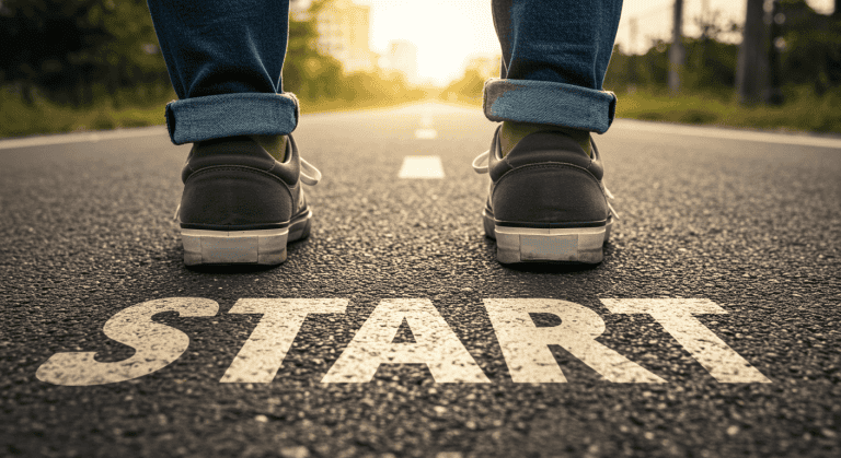 Close-up of a person standing at the starting line on a road with the word “START” written on the ground, symbolizing the beginning of a business journey.