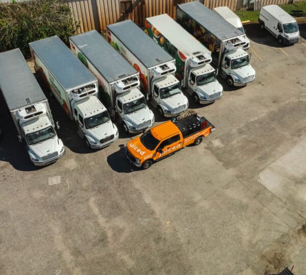 Fleet of commercial trucks with Juiced Fuel delivery vehicle providing on-site fuel services in a logistics yard