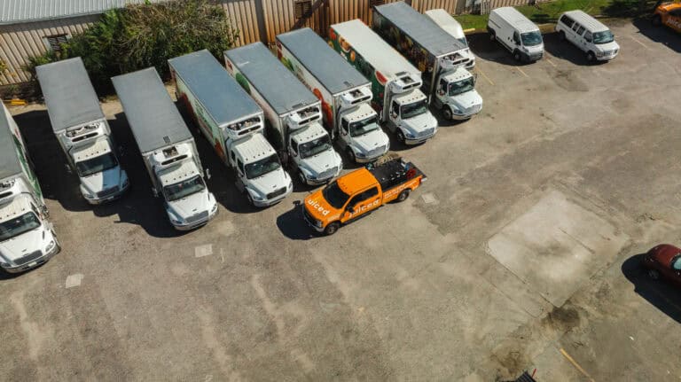 Fleet of commercial trucks with Juiced Fuel delivery vehicle providing on-site fuel services in a logistics yard