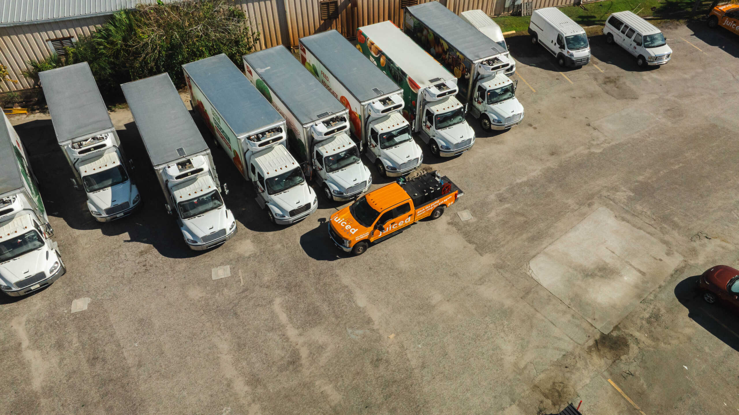 Fleet of commercial trucks with Juiced Fuel delivery vehicle providing on-site fuel services in a logistics yard